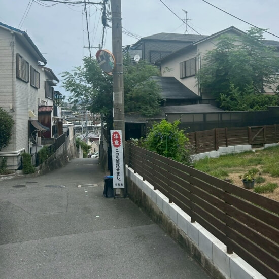 川西市南花屋敷│現場の前面道路に「この先道路せまし」の看板が置かれている風景